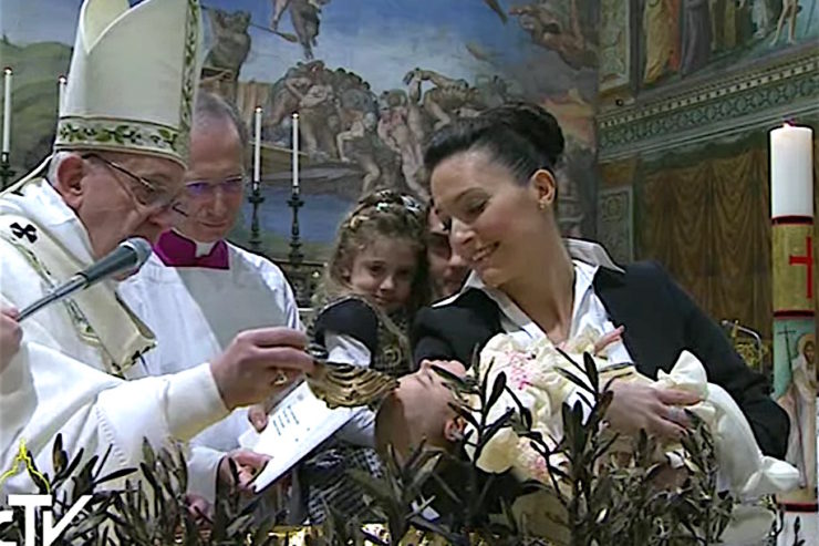 El Papa mientras bautiza a uno de los 28 niños