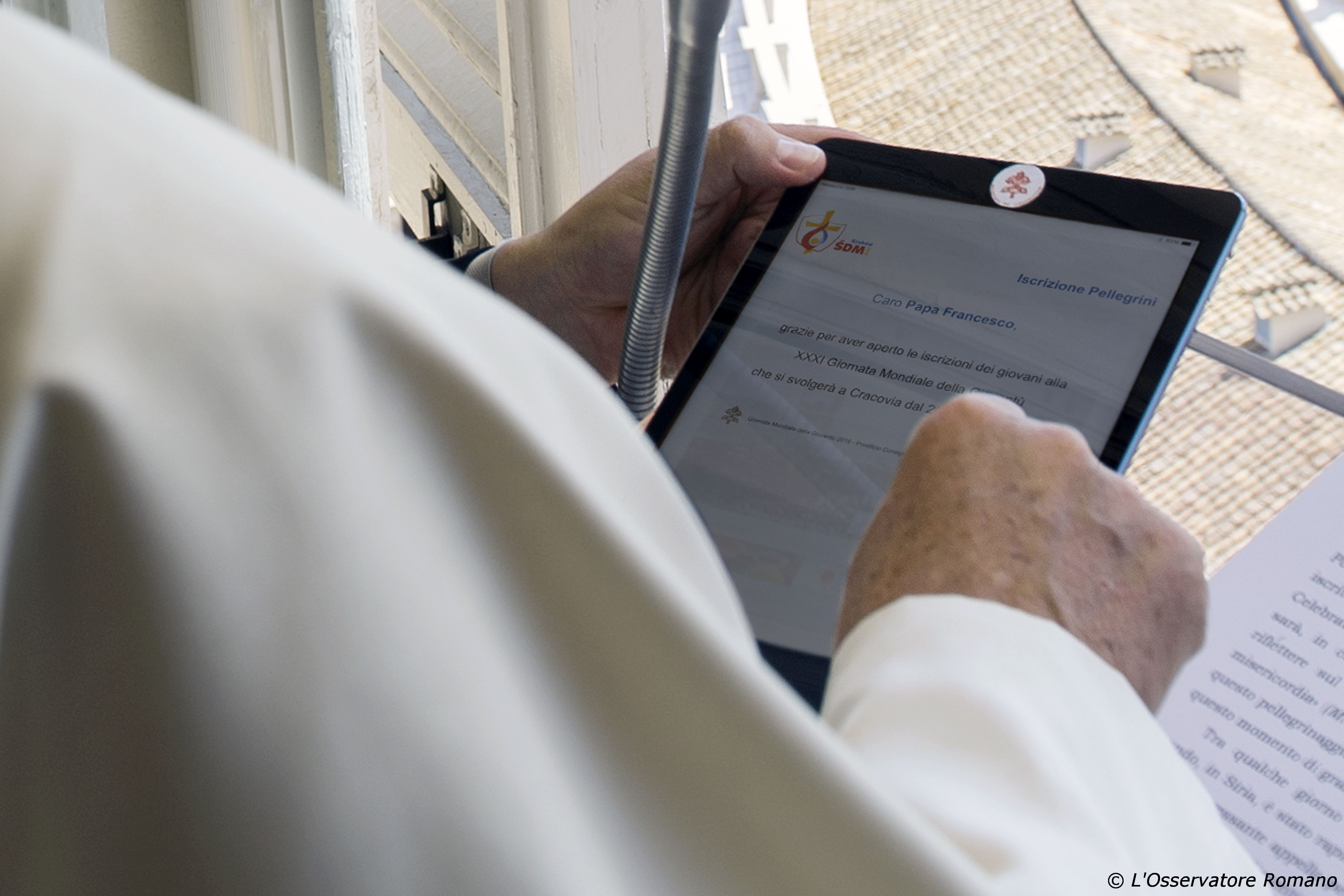 Pope Francis registers himself through a tablet as a pilgrim to the 2016 World Youth Day in Poland