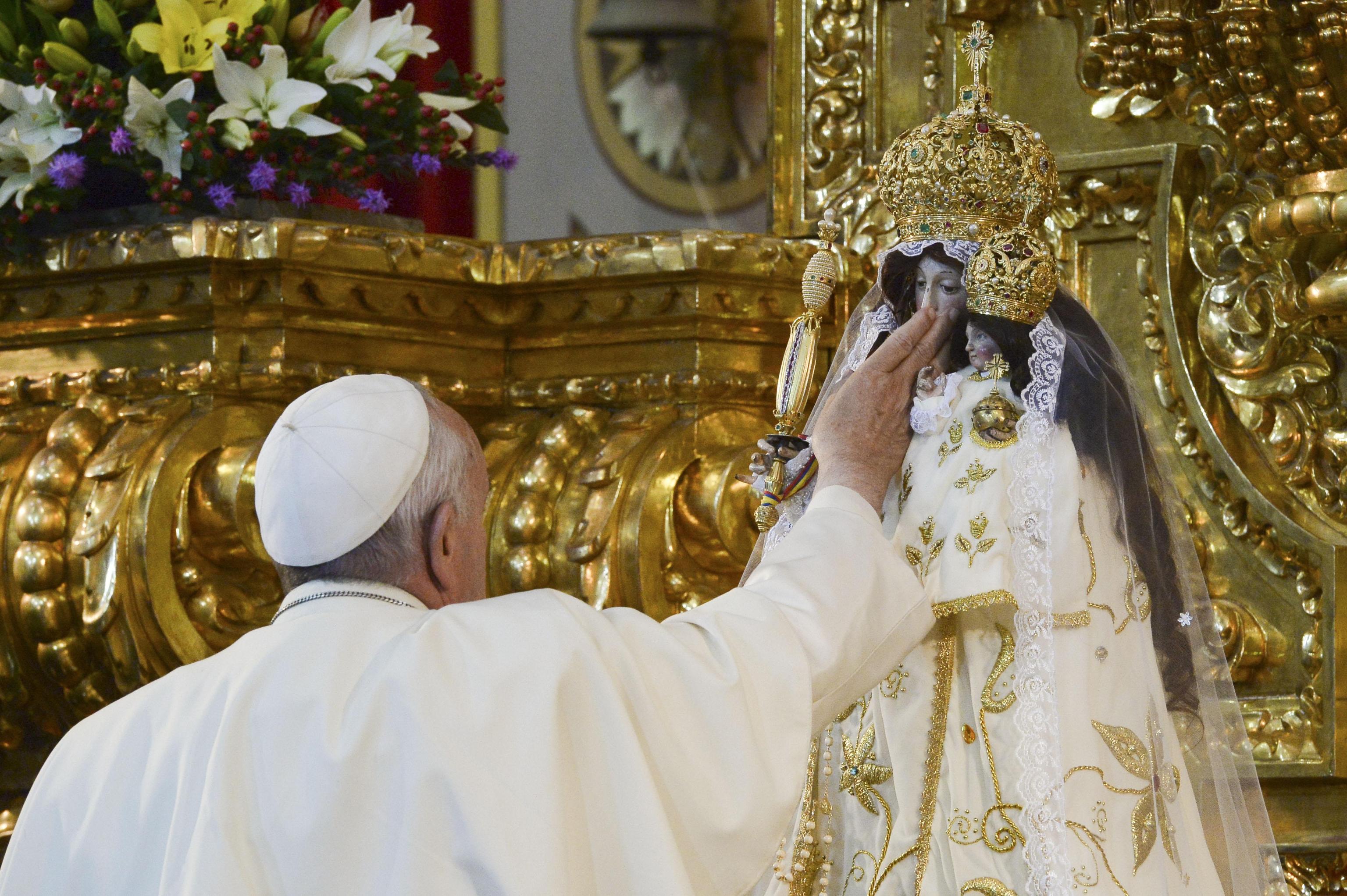 Pope Francis caresses the statue of Our Lady of Quinche