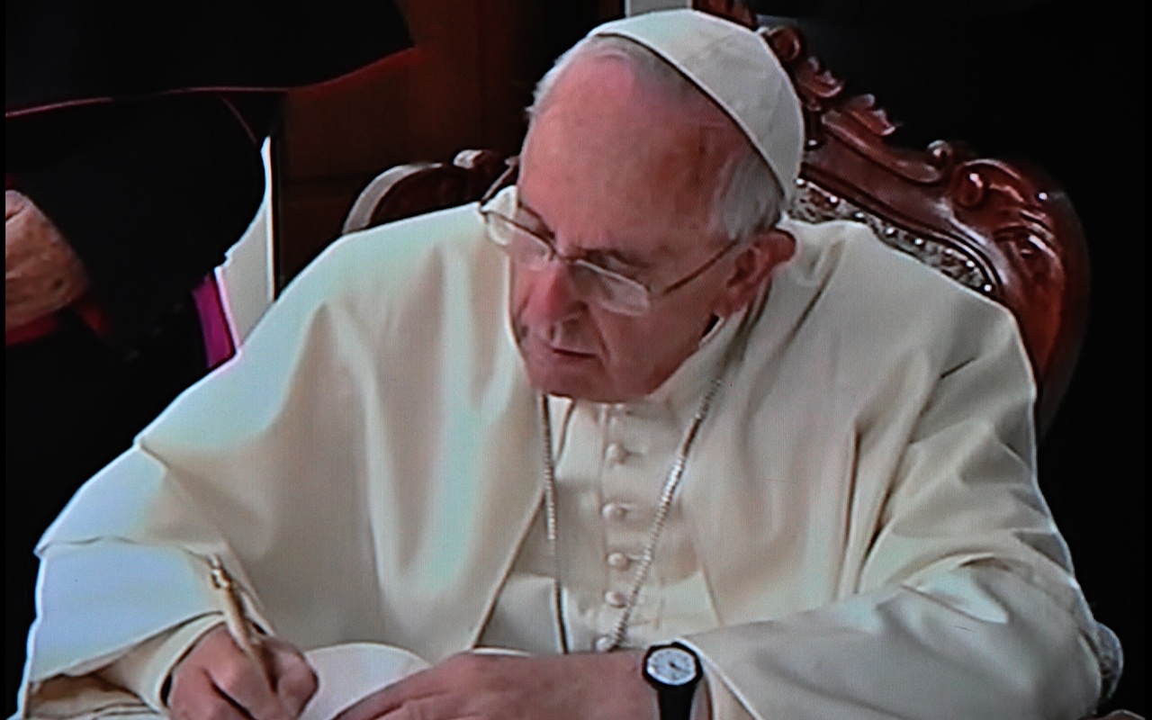 Pope Francis signing the Visitors Record Book of the Sanctuary of the Virgen del Quinche