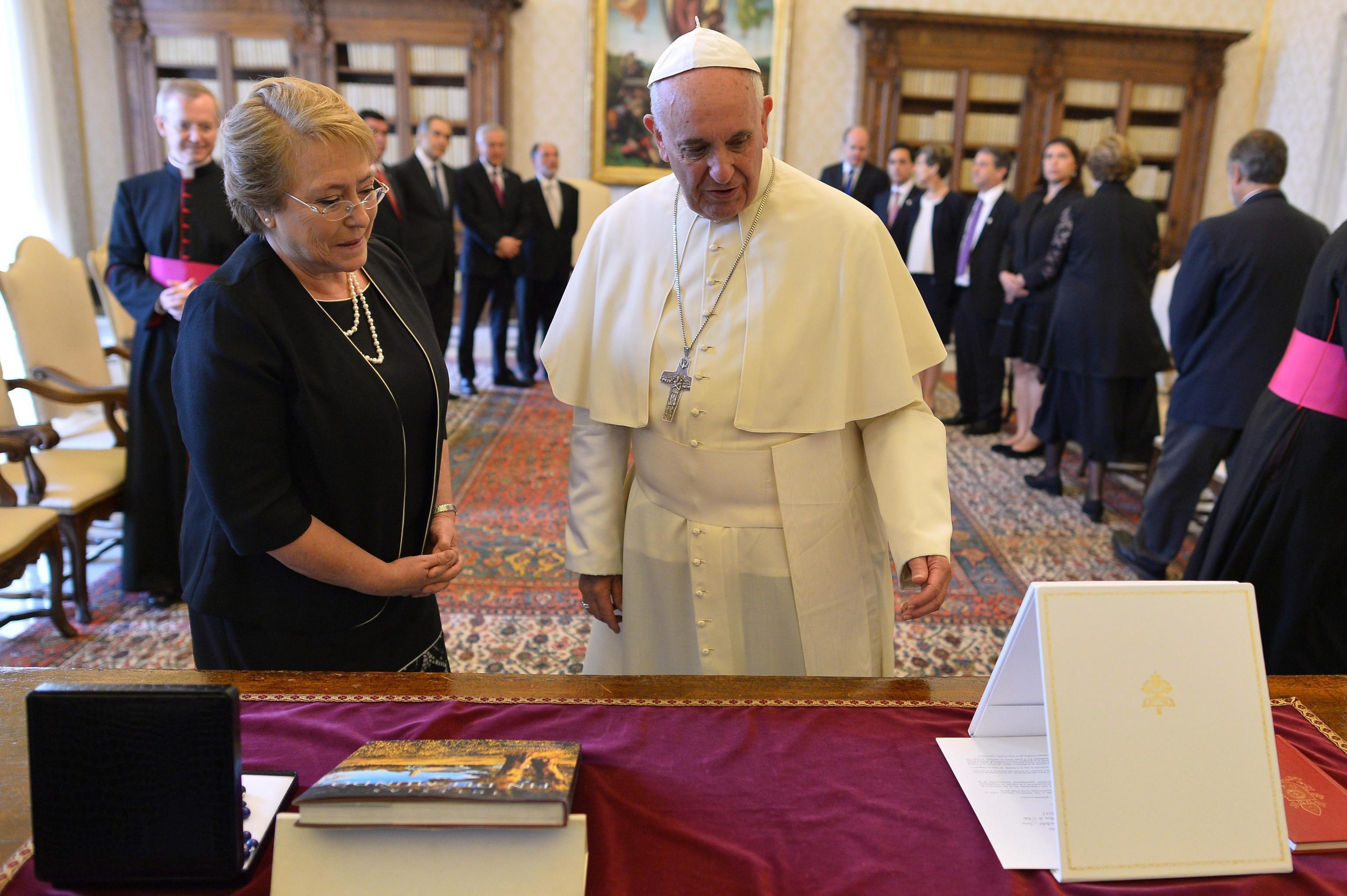 Pope Francis (R) exchanges gifts with Chilean President Michelle Bachelet during a private audience in the Vatican