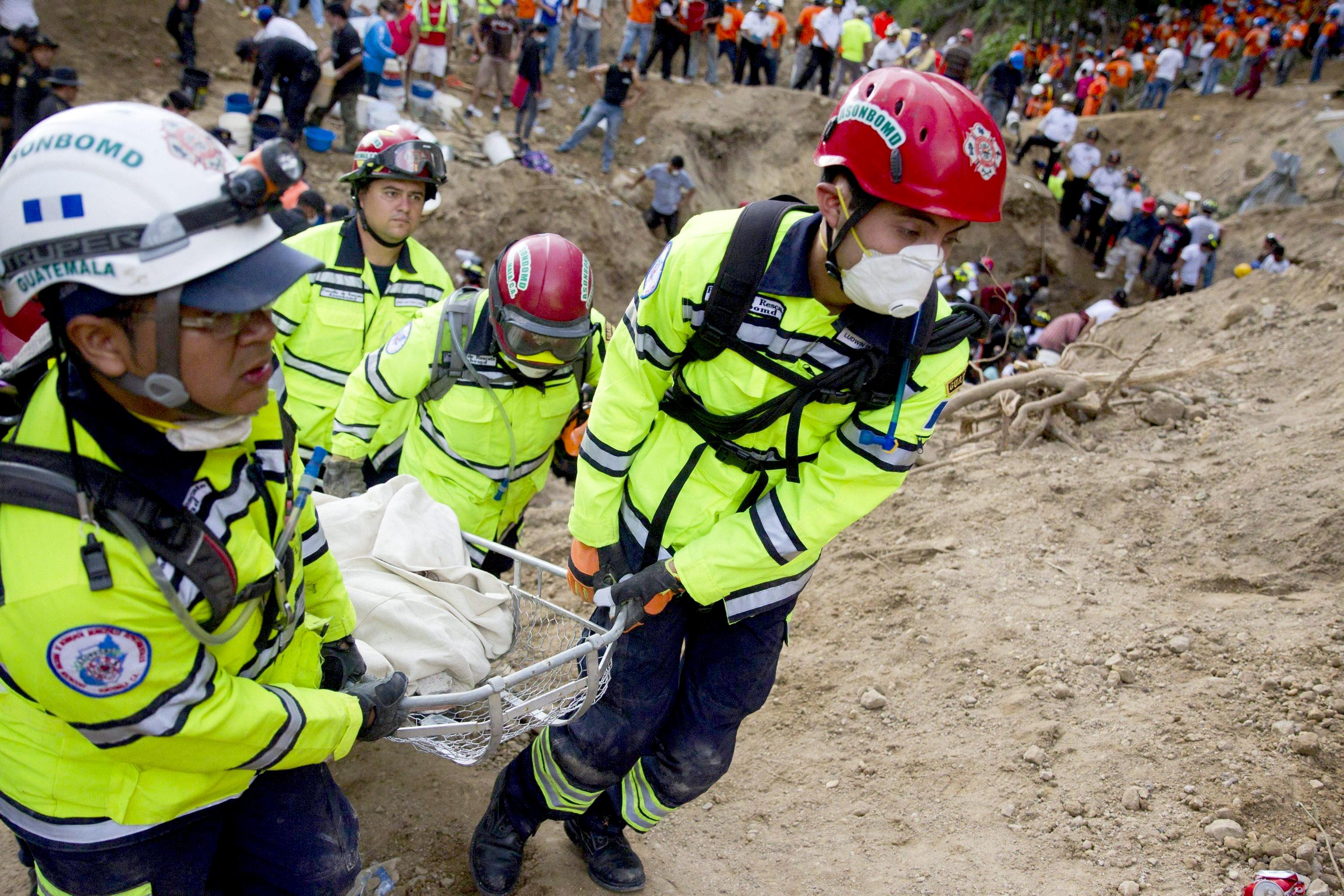 Members of a rescue team recover a body after a landslide in Santa Catarina Pinula municipality