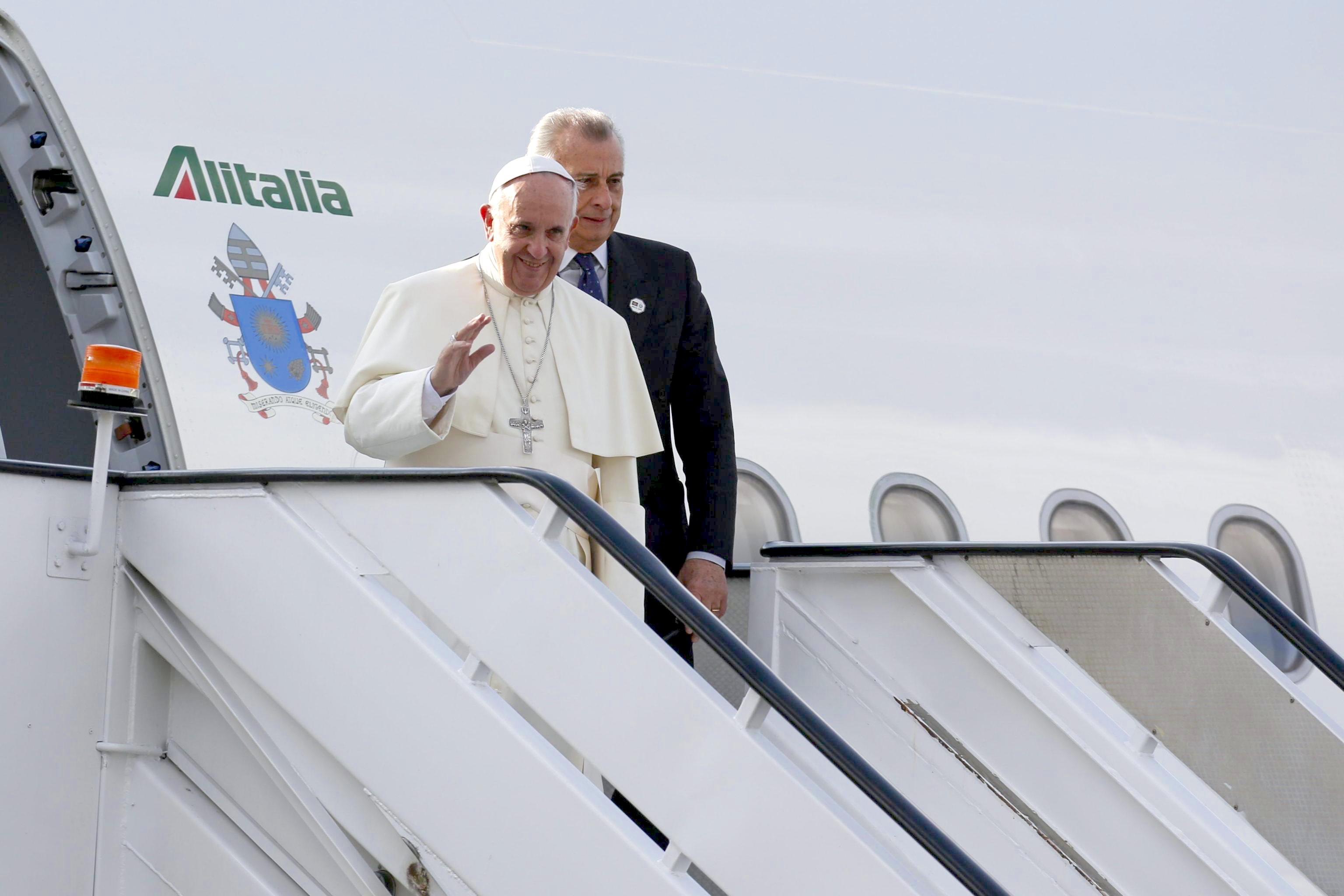 Pope Francis waves as he disembarks after landing at Jomo Kenyatta International Airport in Nairobi