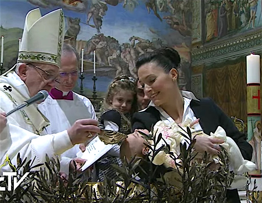 El Papa mientras bautiza a uno de los 28 niños