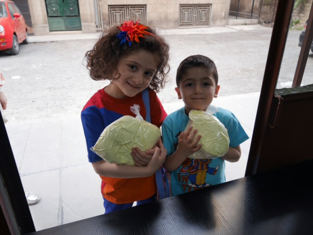 Niños reciben leche en la ciudad de Alepo (Foto Acn)