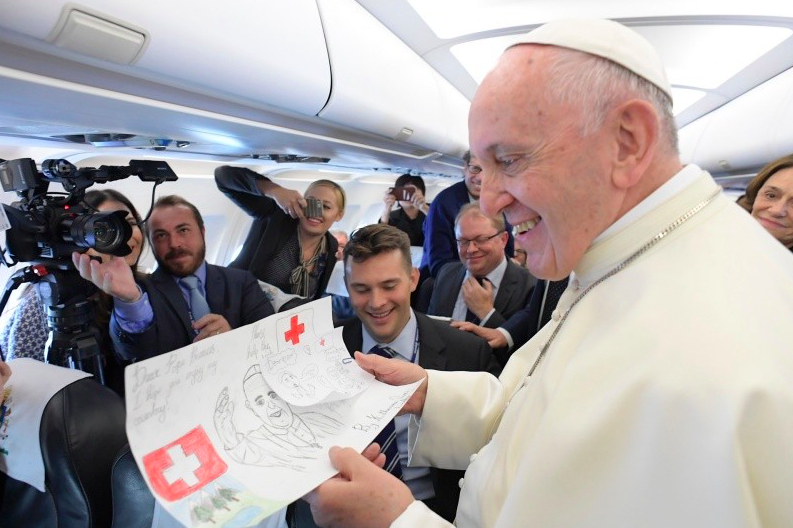 El Papa Francisco recibe un regalo en el vuelo a Ginebra © Vatican Media